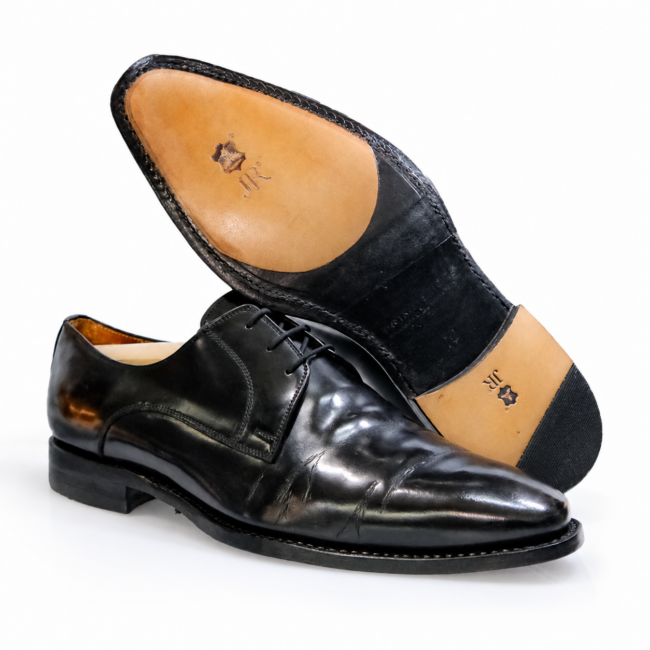 Schwarze Schnürschuhe mit hellem Leder im vorderen Sohlenbereich und kombiniertem Leder-Gummi-Absatz